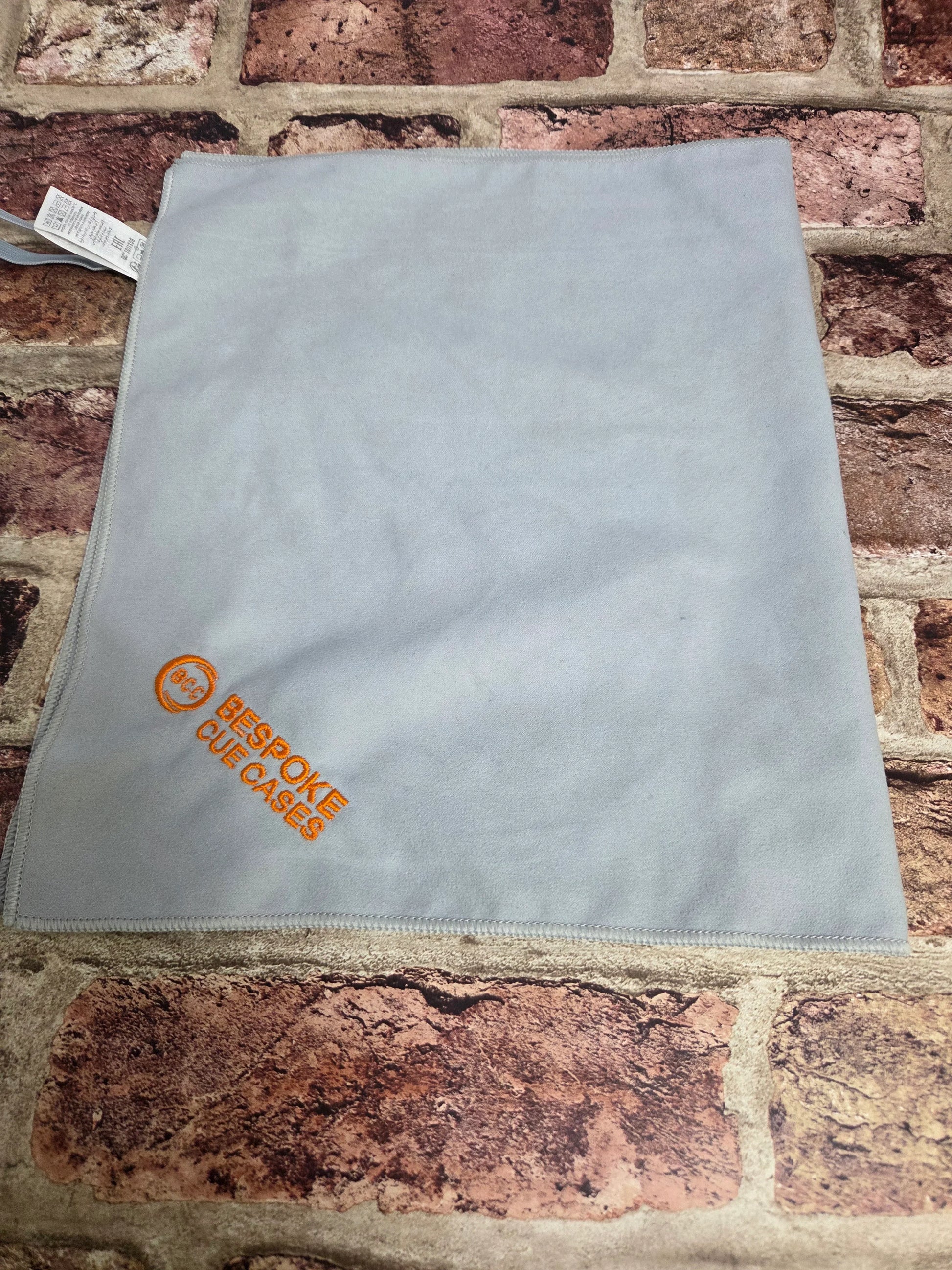 Light gray Bespoke Cue Cases microfiber cloth on a brick background