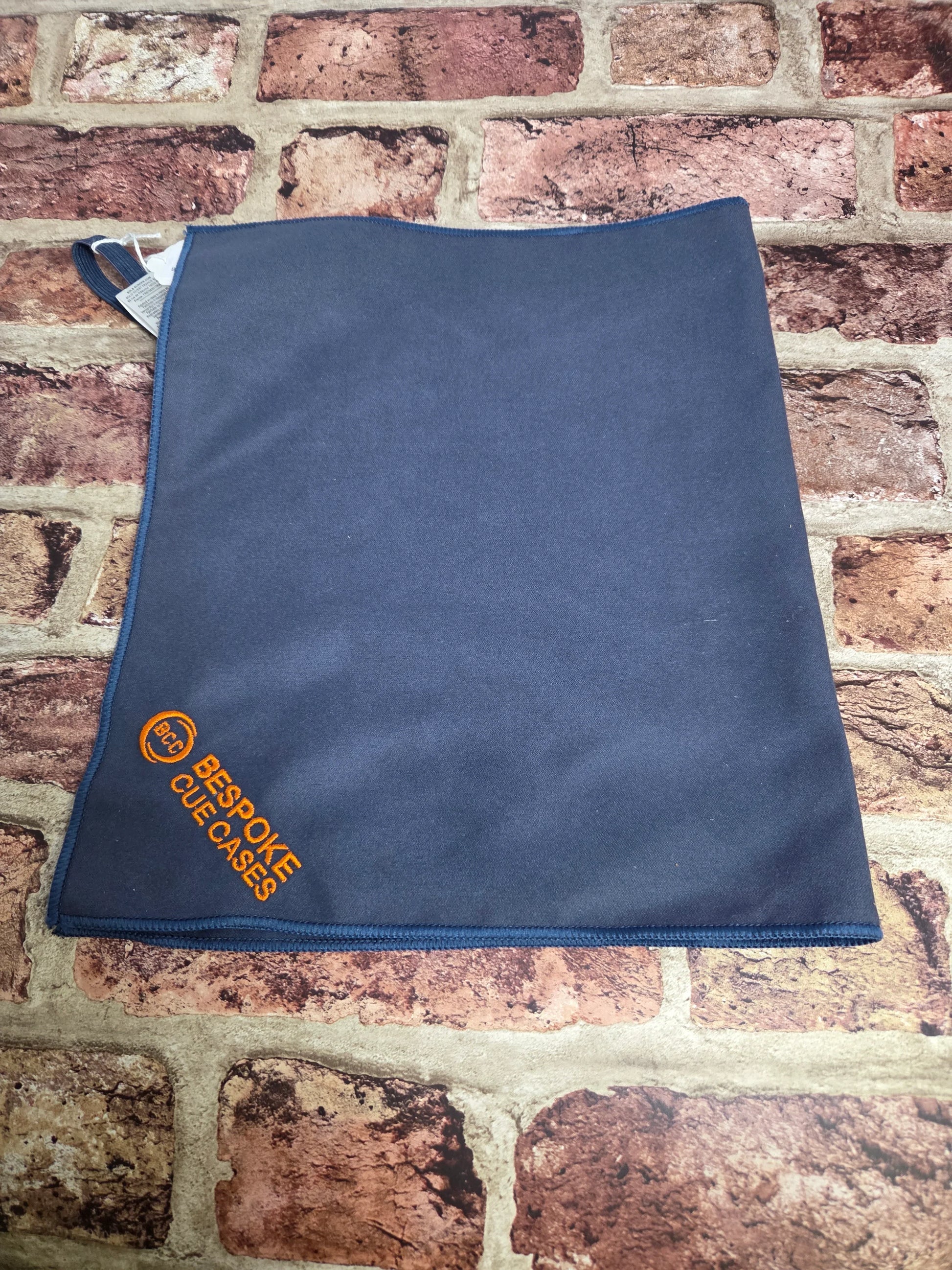 Navy Bespoke Cue Cases cleaning cloth on a brick background